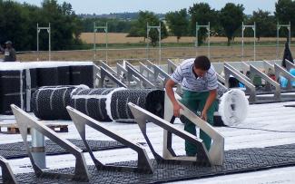 The Fixodrain® XD 20 drainage layer (in rolls), installed across the entire area, is followed by the Solar Bases SB 200, each of which has a Solar Base Frame SGR 35 on which the solar modules are mounted. The Solar Base Frames SGR 35 are being installed